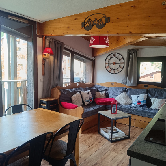 Pièce à vivre avec canapé confortable, jeux de société, vue piste