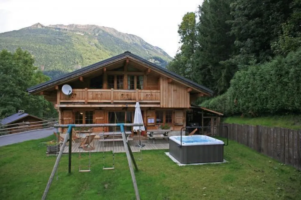 Façade du chalet : terrasse, balançoire, jaccuzzi