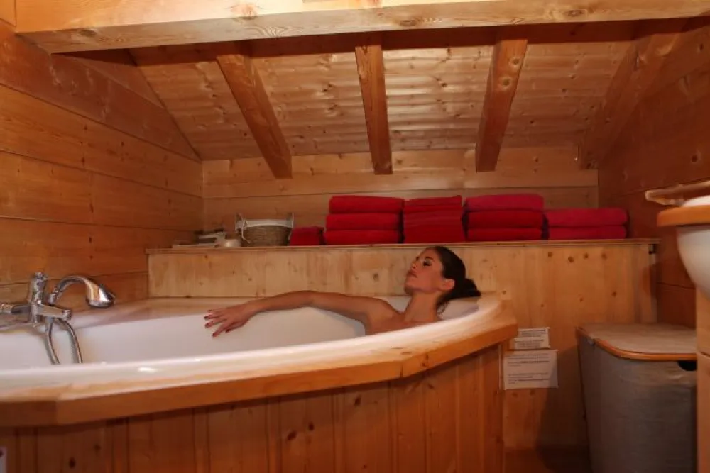 Salle de bain avec vélux situé au 1er étage, avec baignoire d'angle et option balnéo, une cabine douche et un lavabo, sèche-cheveux à disposition. Au sol, un parquet en bois de teck. 5 m2. 