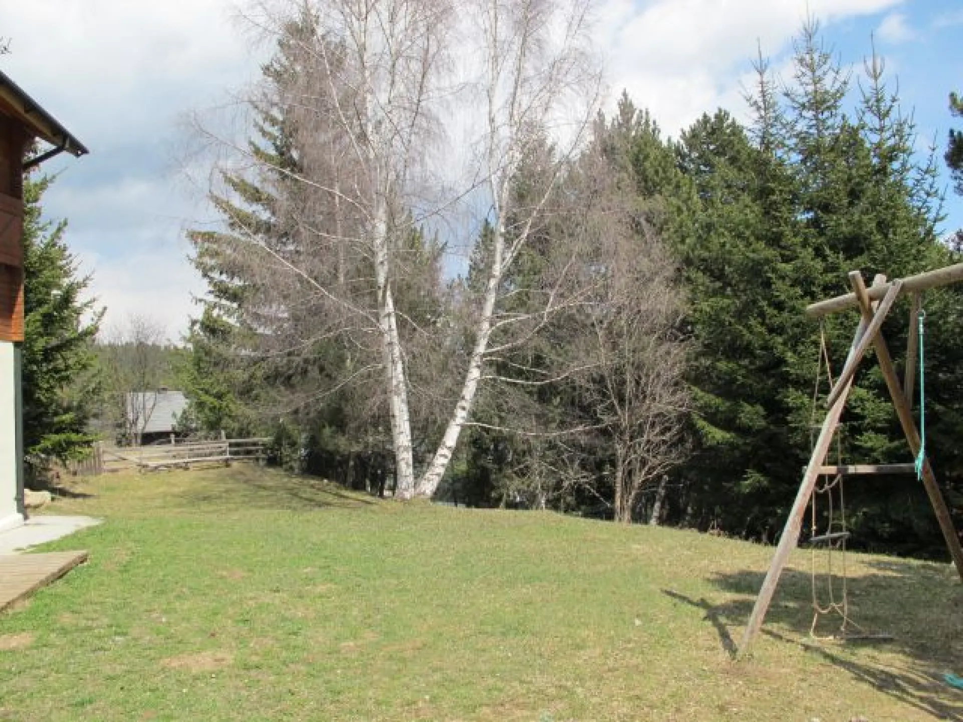Le jardin avec balançoire, toboggan, roulotte pour enfant.