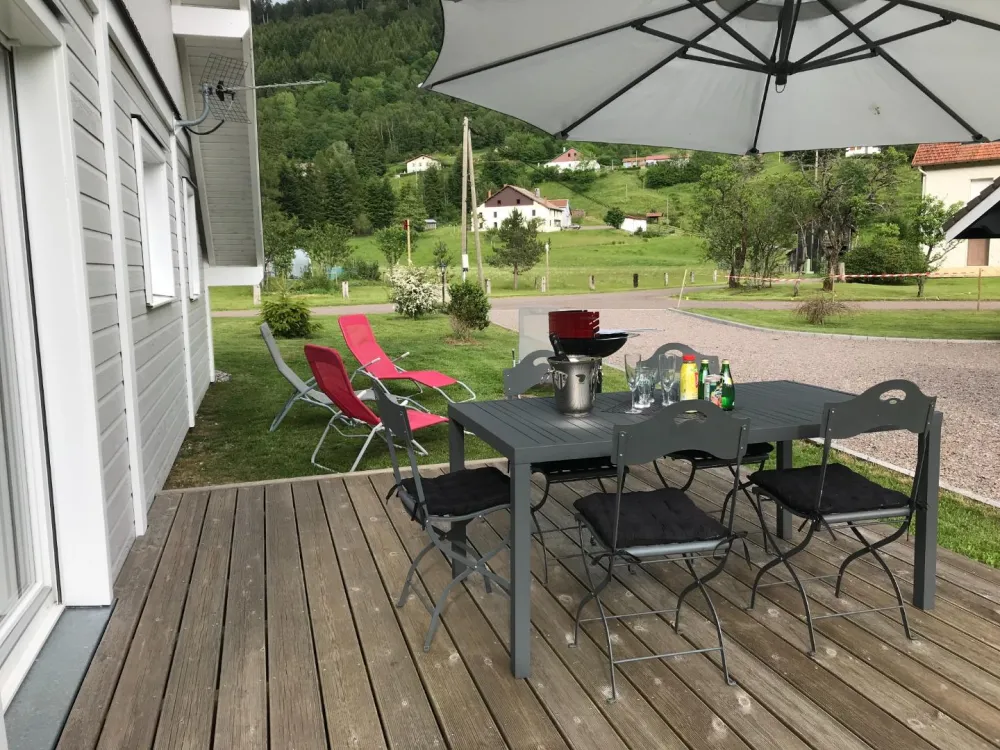 The south-facing wooden terrace with garden furniture - relaxation armchairs - Parasol - barbecue