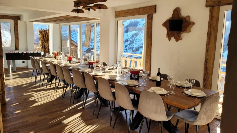 La salle à manger avec une table qui peut accueillir jusqu'à 24 personnes. Cette pièce est ouverte sur le salon et le babyfoot.