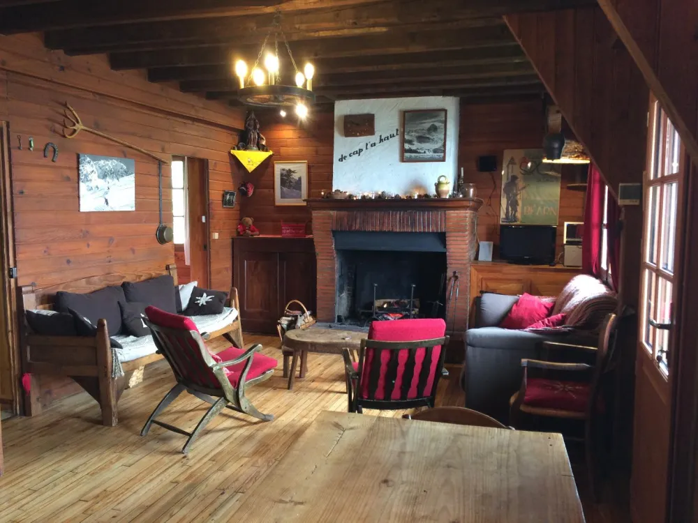 Pièce principale avec le coin salon autour de la cheminée,la grande table et les bancs coté salle à manger.