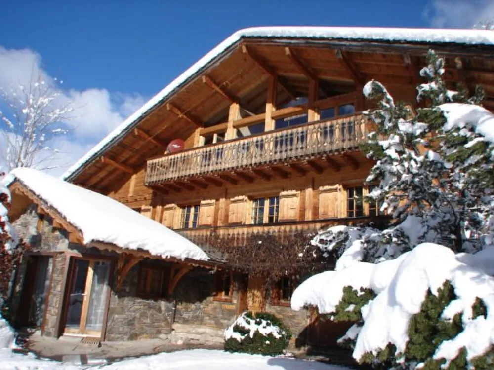 Photo hiver: Dans les alpages orientés plein Sud, le chalet a été construit à l'ancienne en  matériaux nobles : lourds madriers de sapin, moellons de schiste du Pays et couverture en ardoises de Châtel taillées à la main.