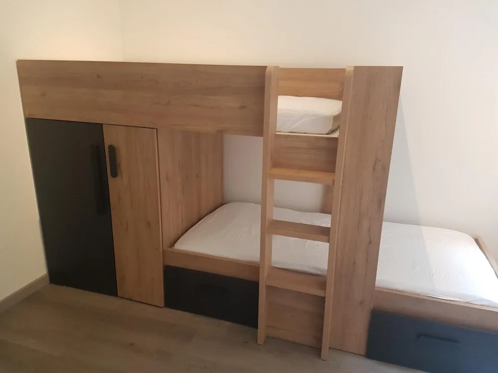 chambre avec lit à étage neuf comprenant tiroir et placard.