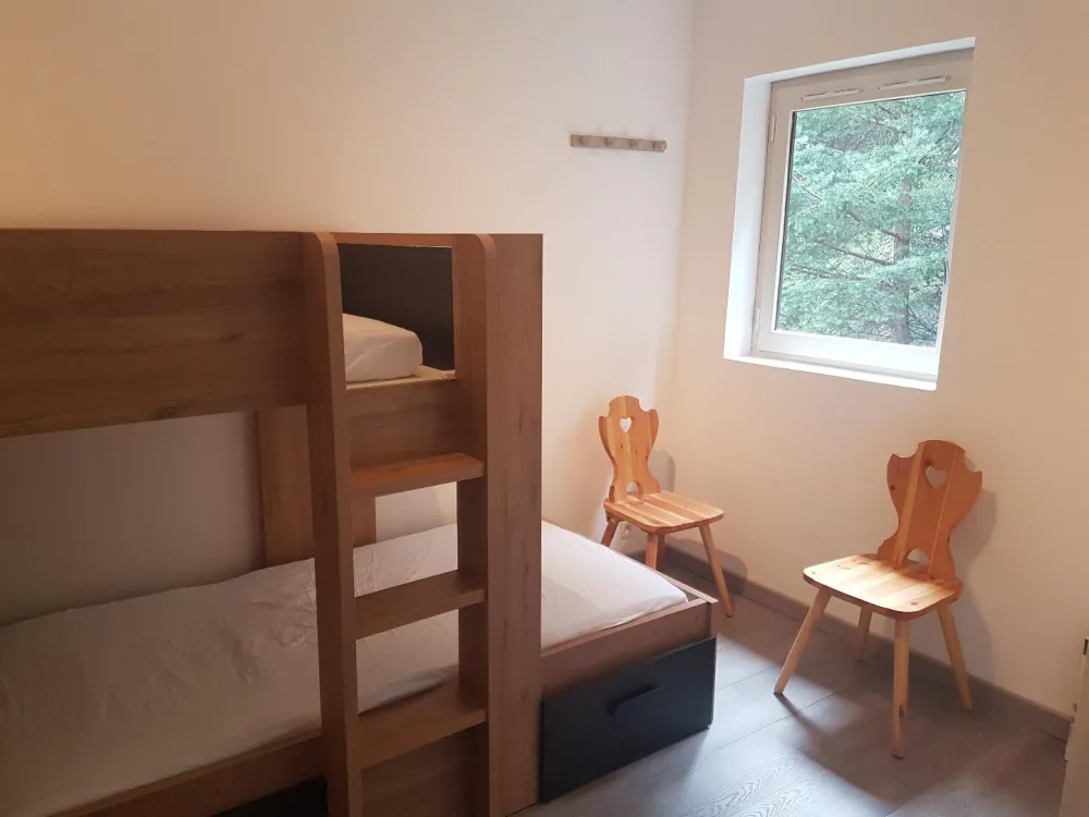 chambre avec lit à étage neuf comprenant tiroir et placard.