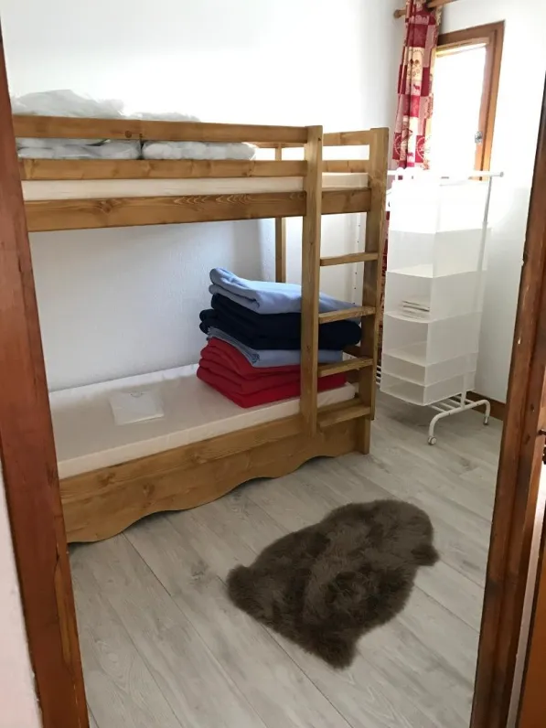 Chambre fermée avec un lit superposé et un lit tiroir que l'on peut tirer en cas de besoin supplémentaire.  Une fenêtre vue montagne