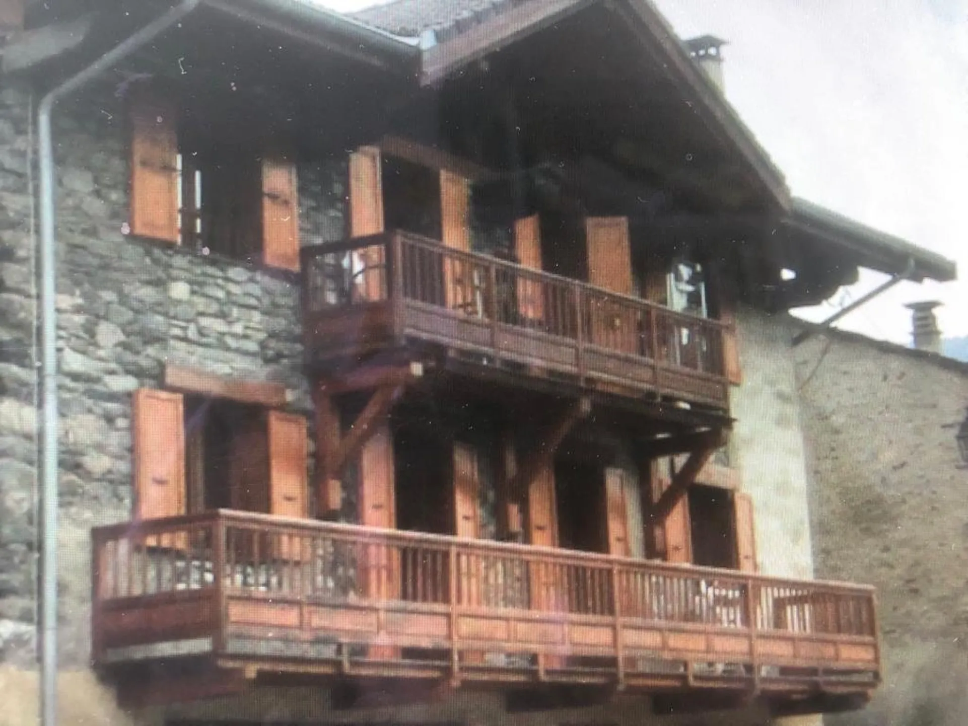Main outside view of the cottage: the charm of wood and stone.