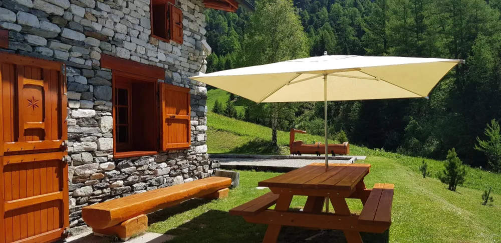 Grande table avec barbecue pour vos repas à l'extérieur.