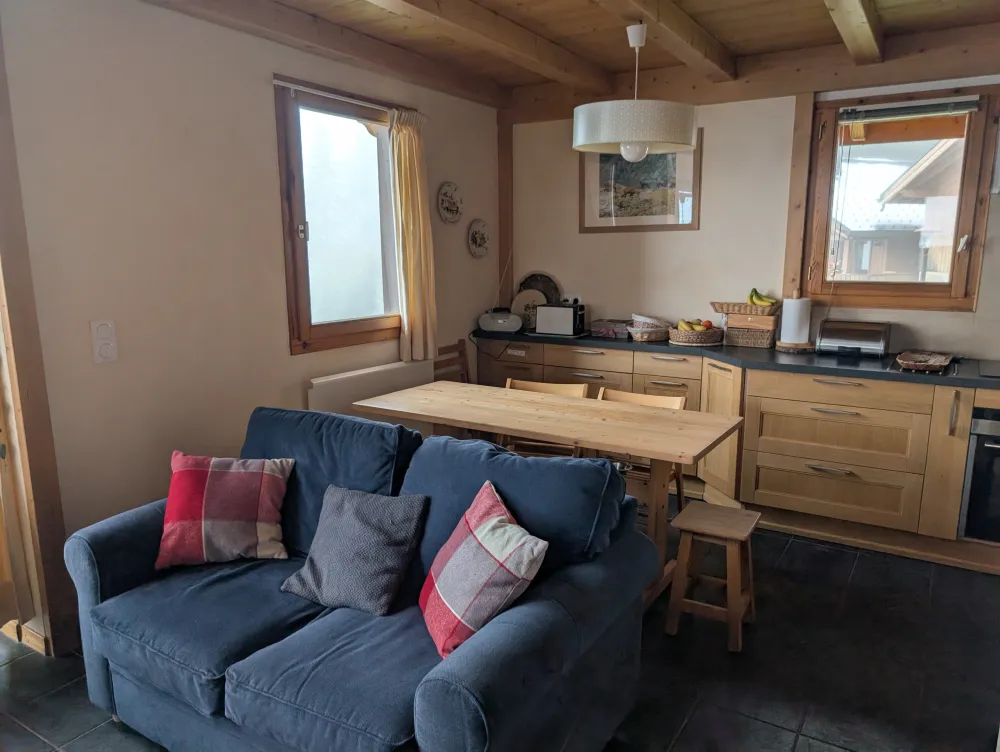 Derrière le salon, la cuisine avec une table qui peut accueillir 6 personnes. Une chaise haute est à votre disposition
