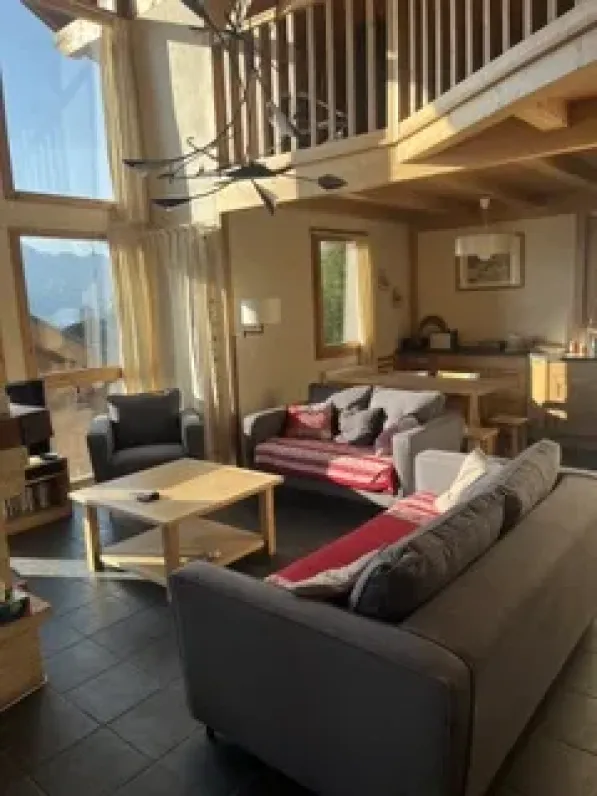 Le salon avec à l'arrière une partie de la cuisine avec une table