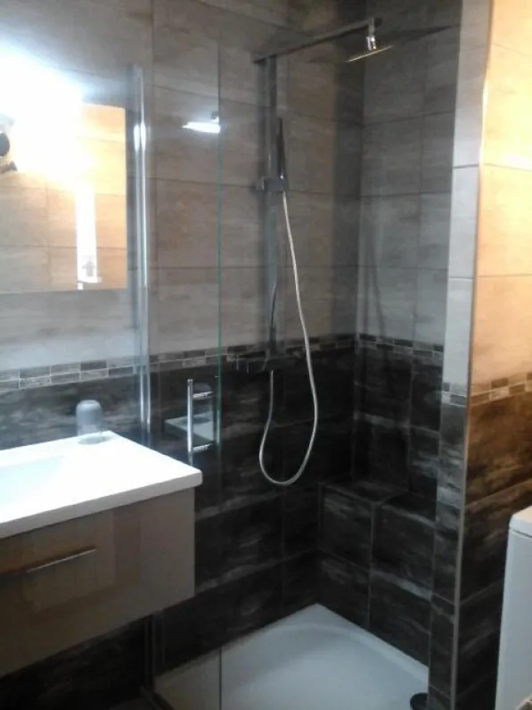 salle de bains  avec douche , lavabo et lave- linge