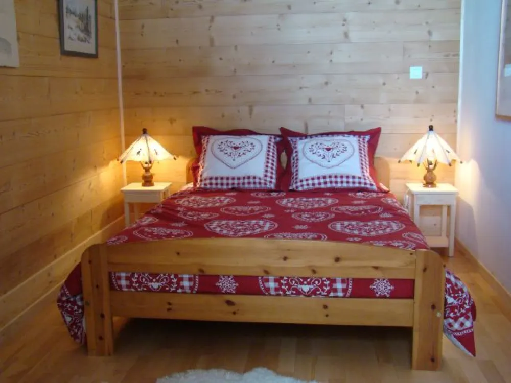 Chambre à coucher : lit avec sommier à lattes et matelas Dunlopillo en bultex 40kg/m3. Les murs sont en bois brossé.