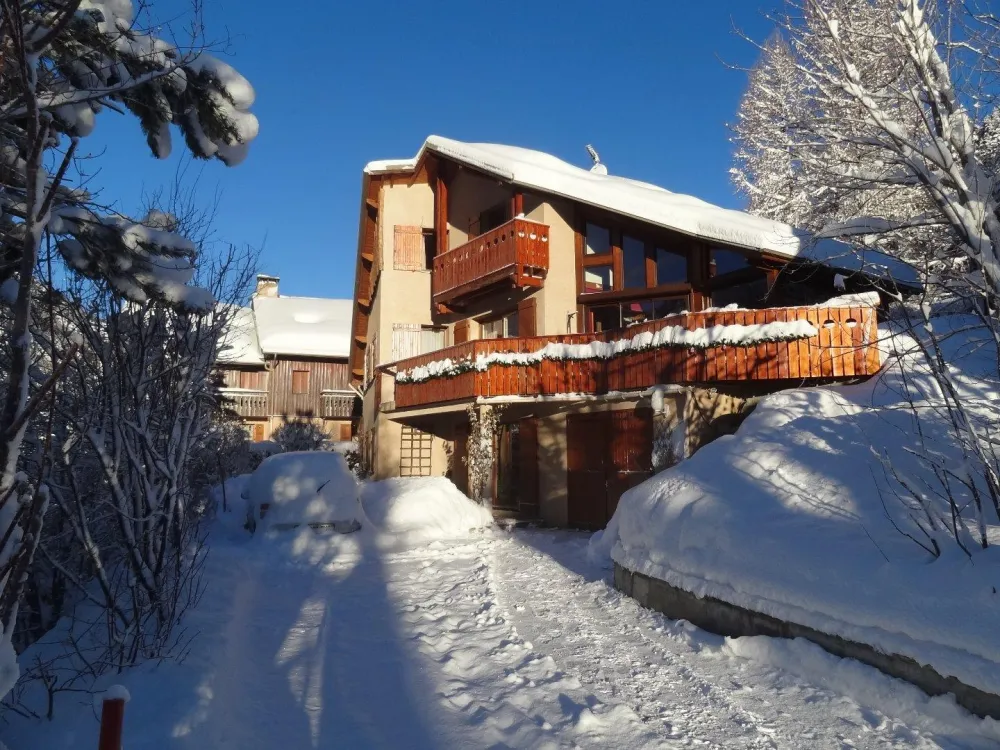 Le chalet en hiver, parking devant, accès déneigé.