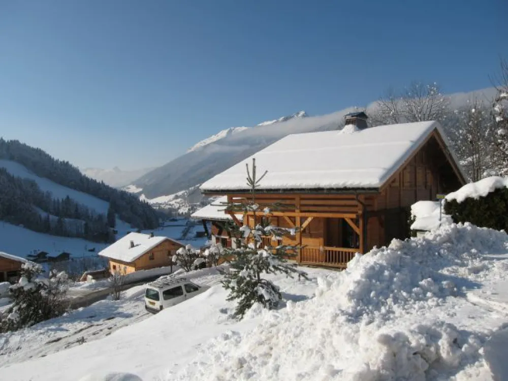View East side of the chalet in winter
on background the village Le Grand Bornand