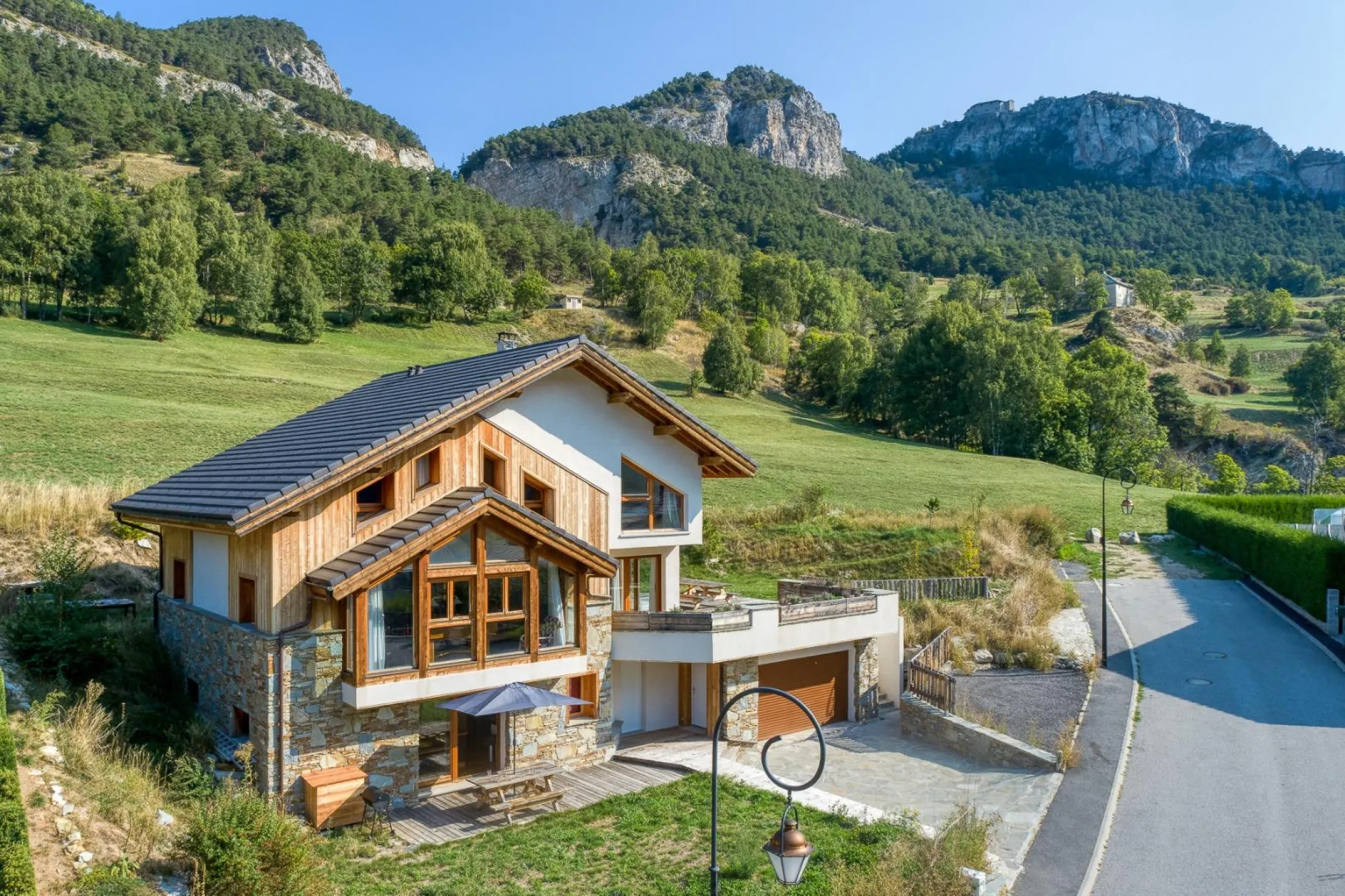 Chalet de la Cascade. Au sommet de la falaise derrière, le fort Marie Christine. Derrière la raie d'arbres au sommet du pré, on trouve la cascade St Benoit.