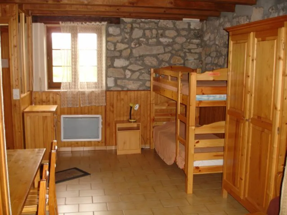 Deux lits superposés (sommier à lattes).
Armoire de rangement. 
Fenêtre donnant sur le terrain à l'avant du chalet.