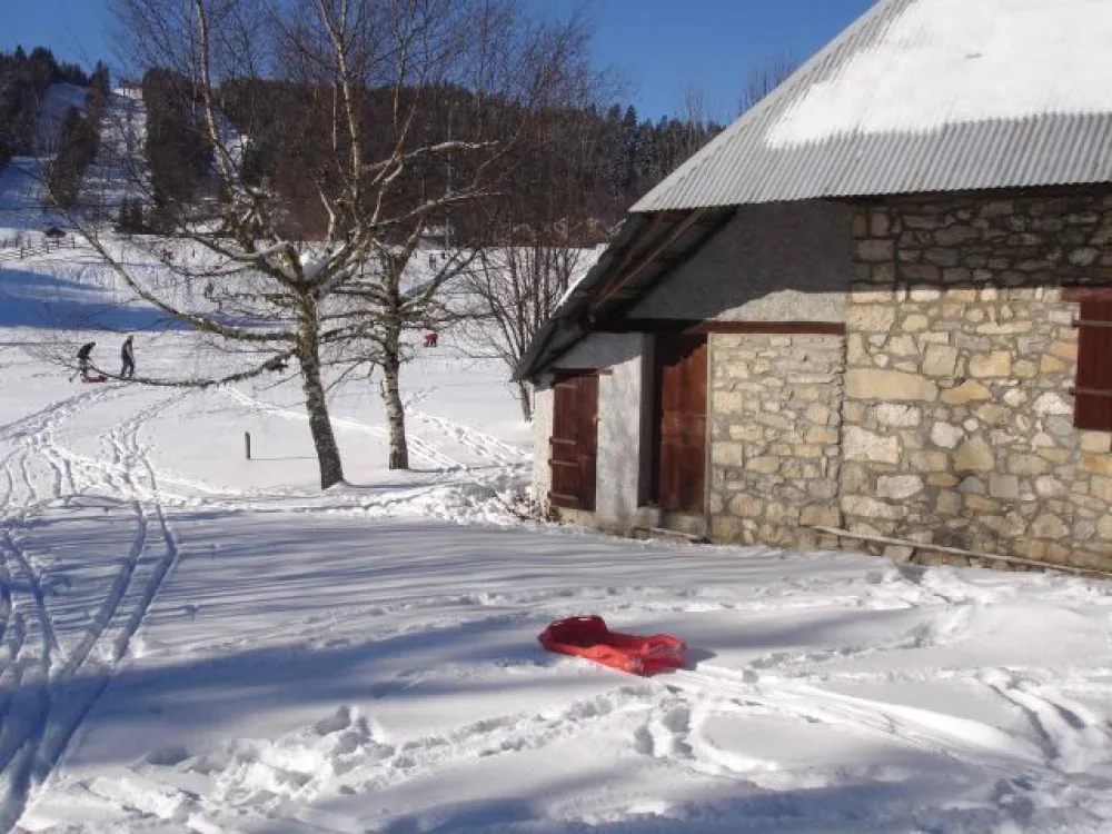 Les pistes de ski de fond passent juste derrière le chalet. Le départ du ski de piste est juste derrière la butte.