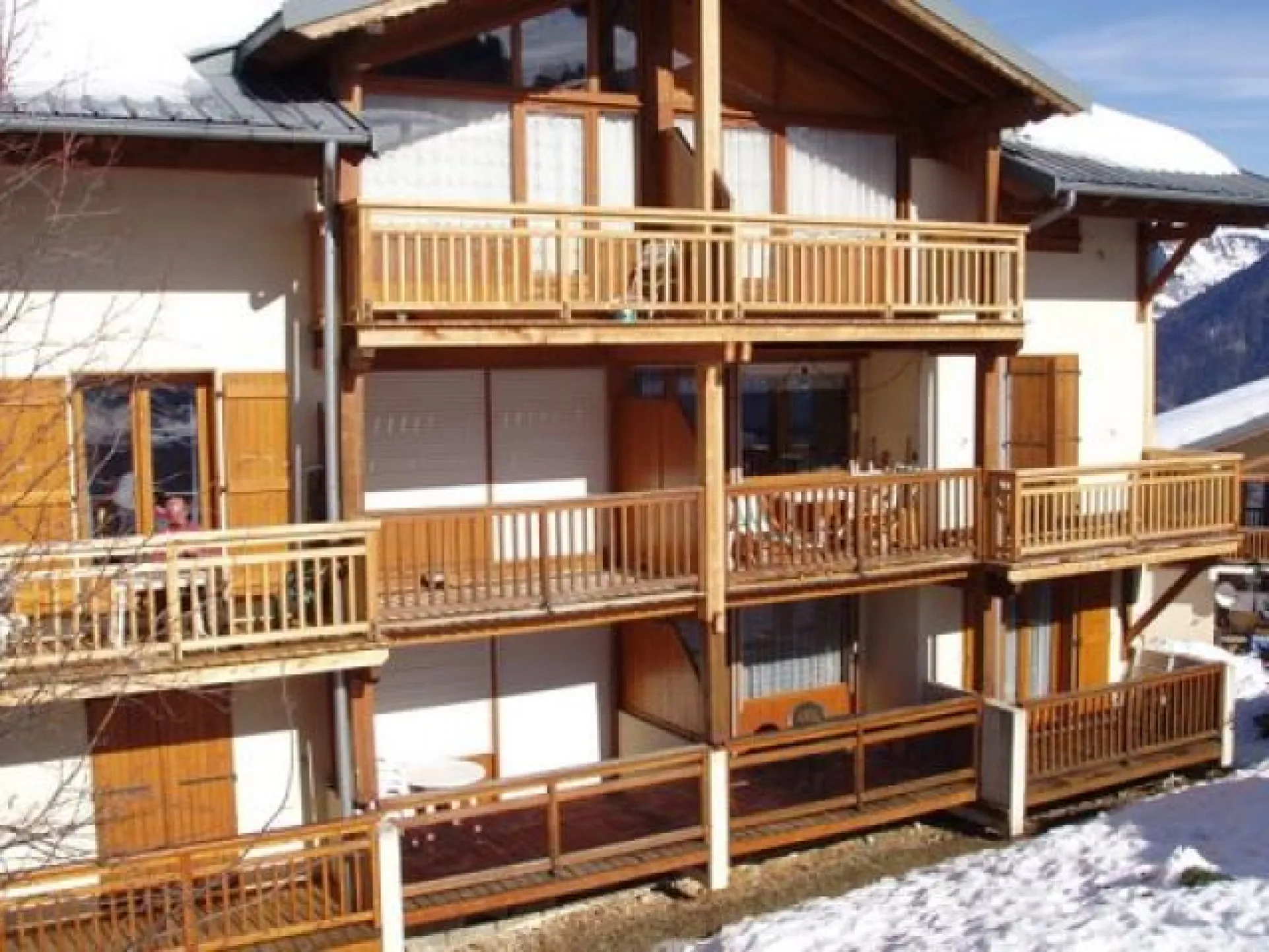 Vue sue le chalet, à droite en bas, les balcons sur la chambre et la pièce à vivre avec salon de jardin.