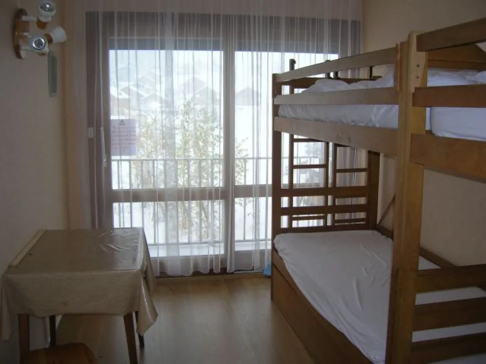 Chambre donnant sur un balcon. 2 fois 2 lits superposés. Grand placard de rangement et penderie. 2 grands tiroirs sous les lits.
Parquet tout neuf.