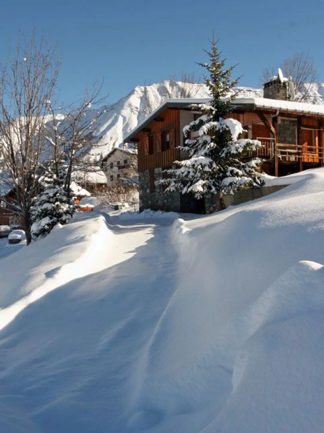 Le chalet, ses abords et son parking en hiver.