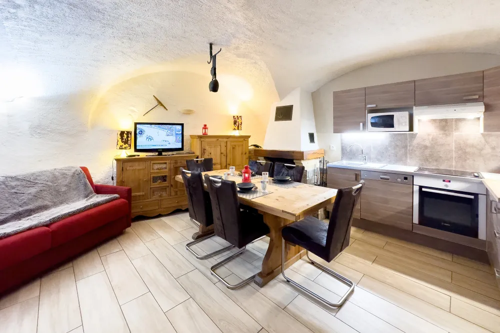 Salle voûtée avec cuisine hyper-équipée et cheminée avec insert