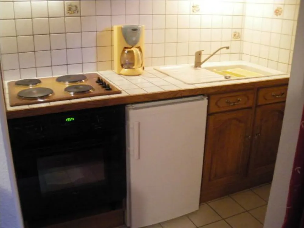 Kitchenette avec table de cuisson ; four à pyrolyse; réfrigérateur avec compartiment congélateur 4*; cafetière traditionnelle et à dosettes; hotte aspirante; éléments hauts et bas avec vaisselle et ustensiles de cuisine.