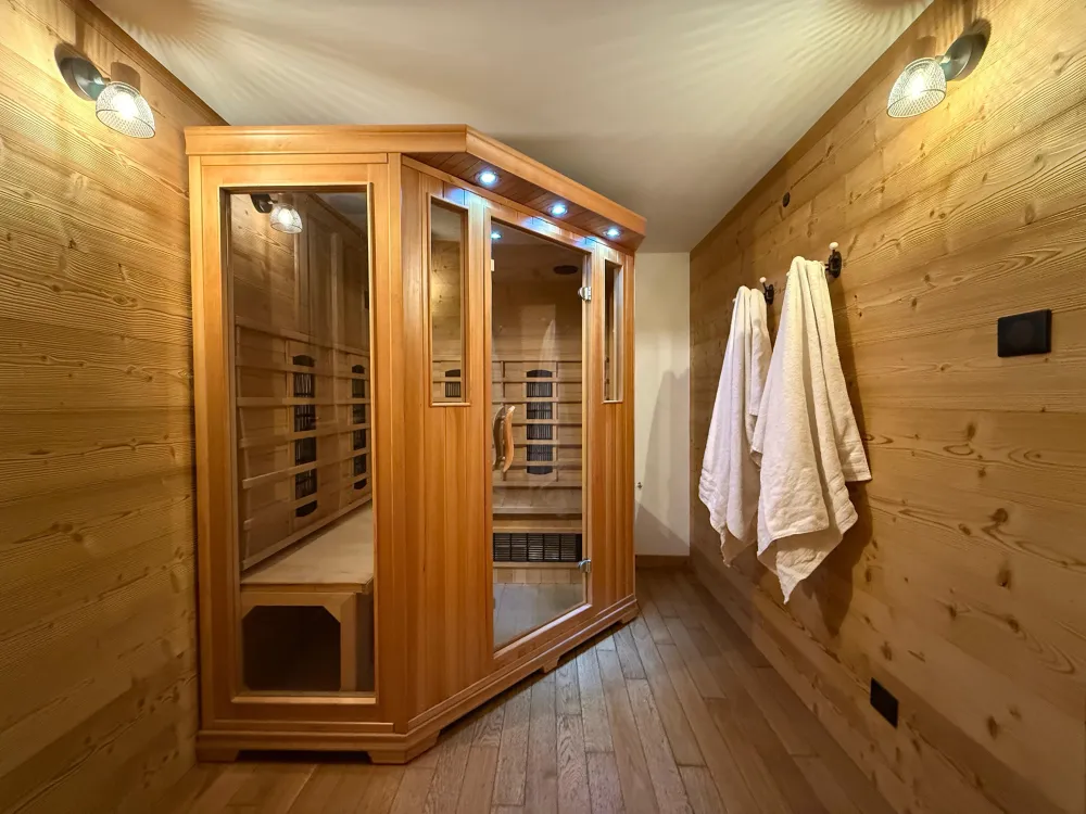 Après une journée sur les pistes, la chaleur du sauna enveloppe le corps, le bois embaume, le silence s'installe. Cabine 3 places rénovée en 2025, un rituel simple avant de retrouver le confort du chalet.