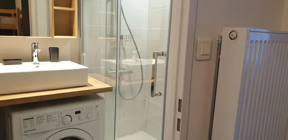 Salle de bains avec douche à l'italienne spacieuse et lave linge