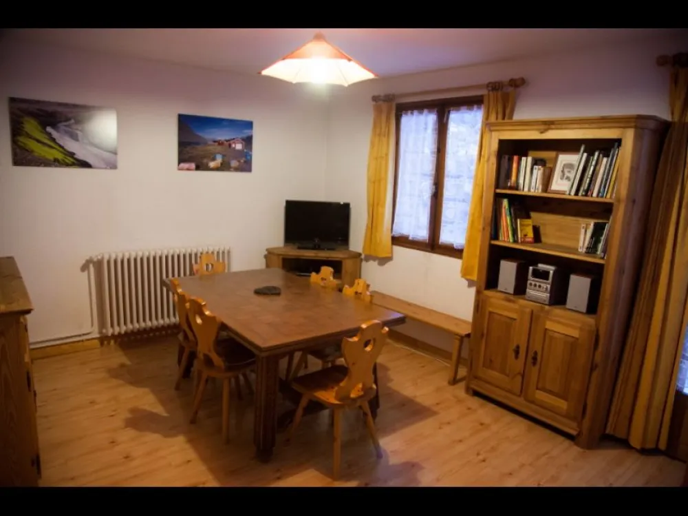 Salle de séjour avec canapé convertible gigogne. Bibliothèque. Téléviseur couleur avec lecteur DVD. Sur demande lit bébé et chaise haute.