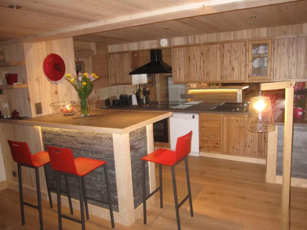 Cuisine aménagée. Plaques inductions, four, micro ondes, lave vaisselle.
Bar convivial avec 4 tabourets hauts