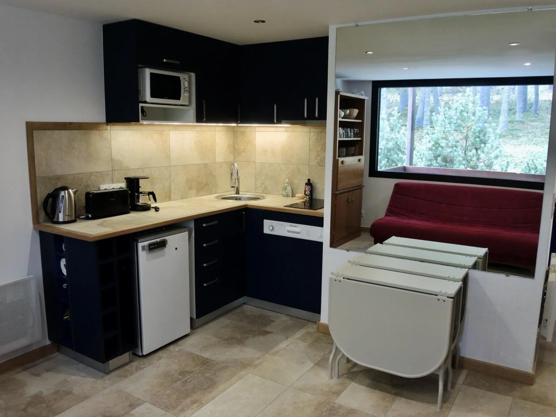Kitchen with its cupboards, refrigerator, dishwasher, microwaves, toaster, coffee- machine, kettle and teapot 