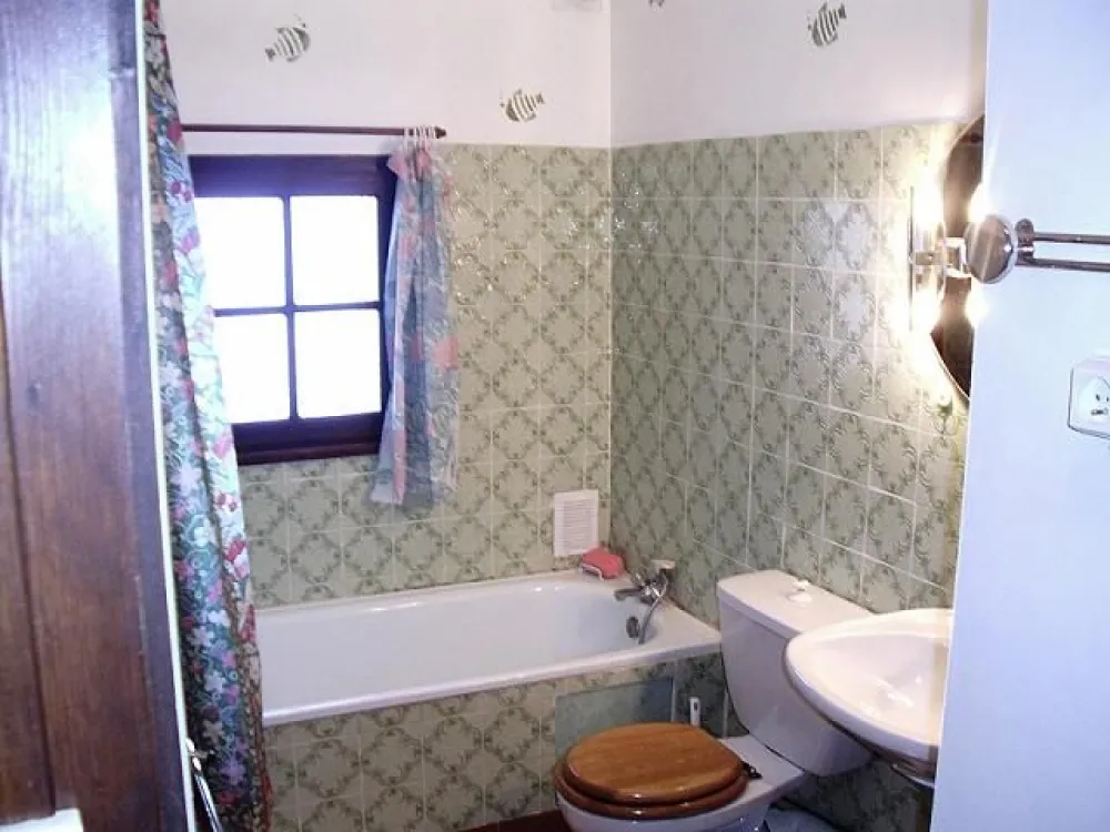 Salle de bain avec baignoire et toilette.
