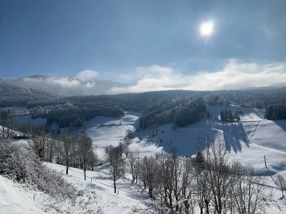 Vue sur la vallée et les pistes depuis le chalet, en hiver