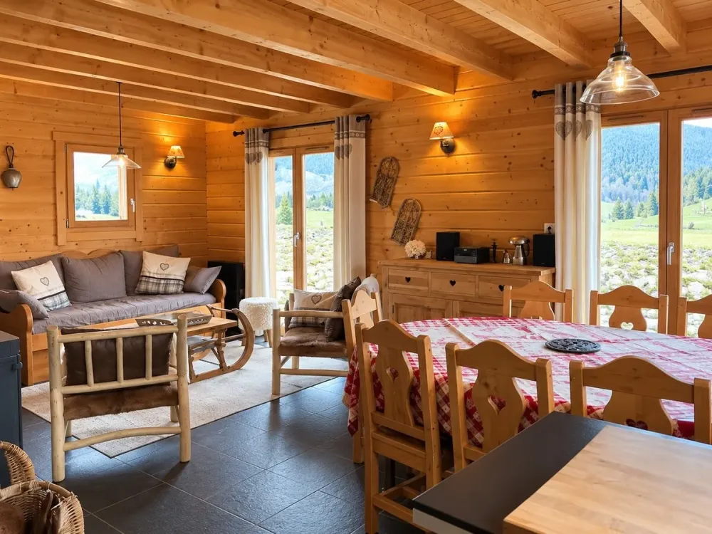 Grande pièce de vie avec salon, table et baies vitrées