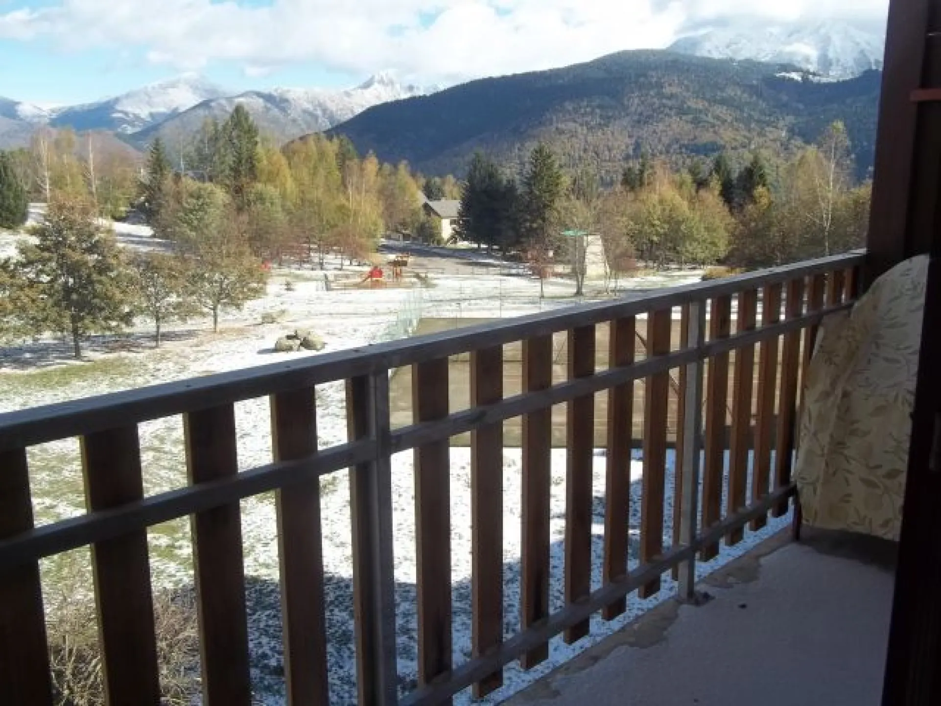 View from the balcony overlooking the rear of the building. Green, children's playground, rock climbing, tennis, swimming and mountain.