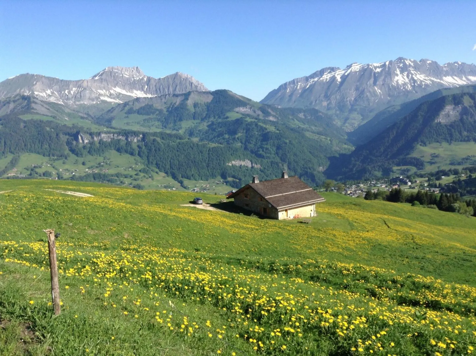Le chalet au cœur des alpages, la chaîne des Aravis dans l fond