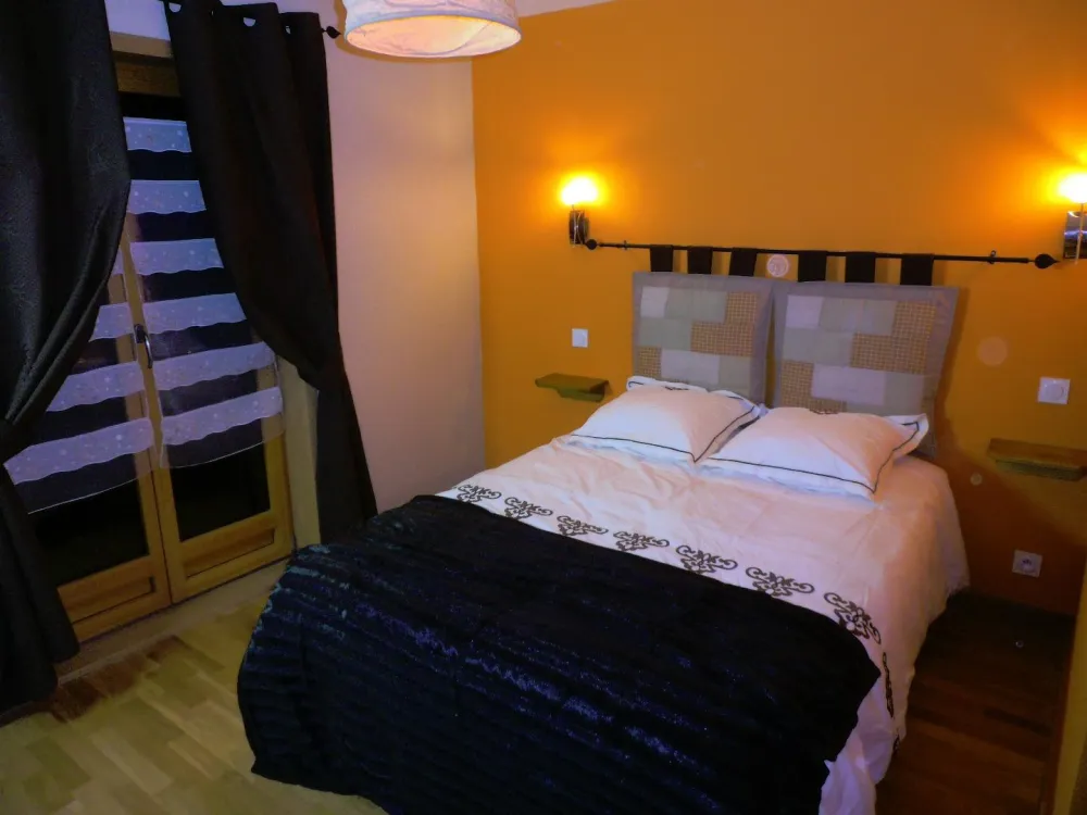 Chambre 2 avec lit double 140 et porte fenêtre sur le balcon à l'avant du chalet