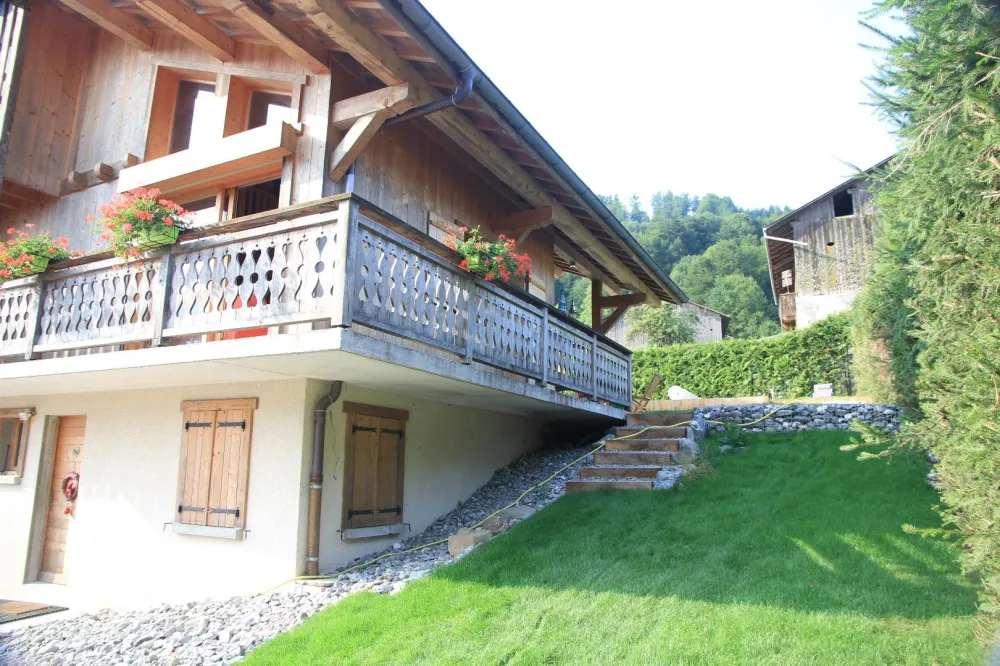 vue partielle du chalet l'été, partie latérale du jardin