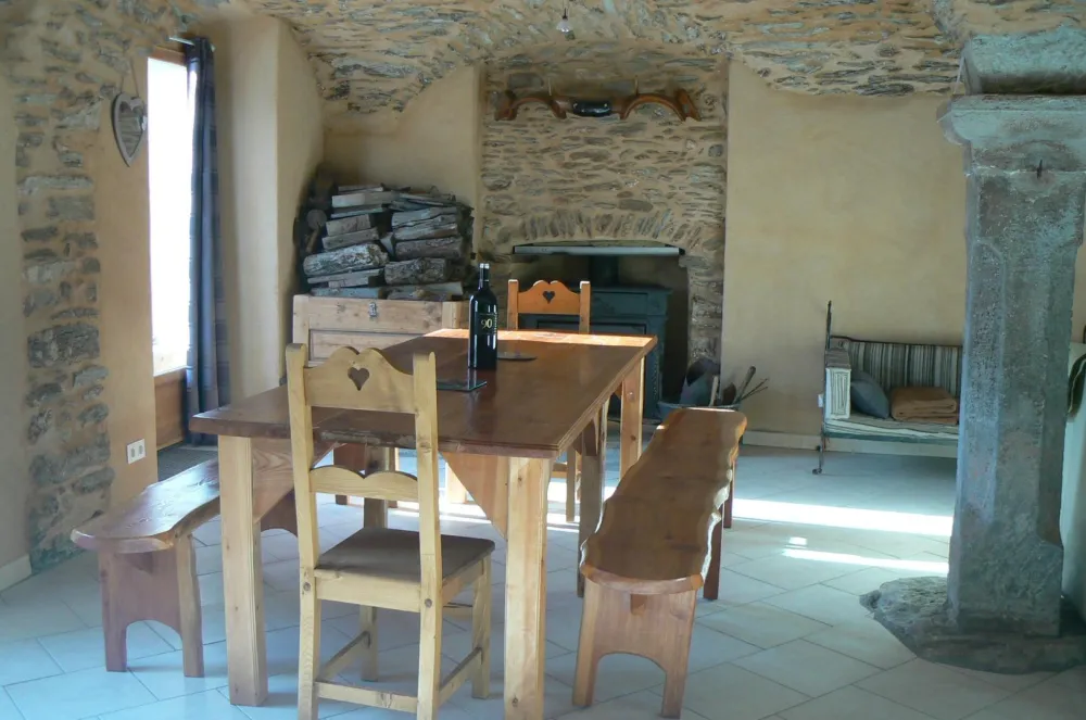 Salle à manger dans une grande pièce à vivre de 60 m2 comprenant deux piliers sous des plafonds voûtés .Vous pourrez profiter d'une flambée dans la cheminée avec insert. 