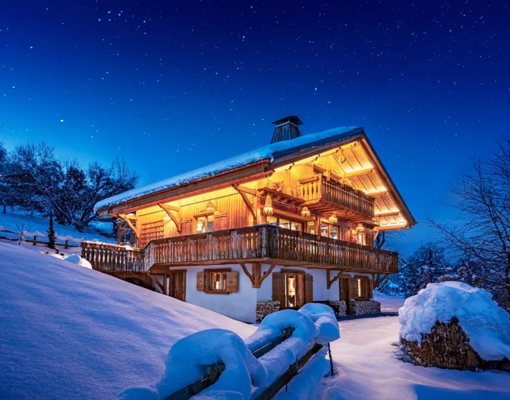 Jardin, extérieur - Les illuminations de la façade mettent en valeur le chalet au crépuscule. 