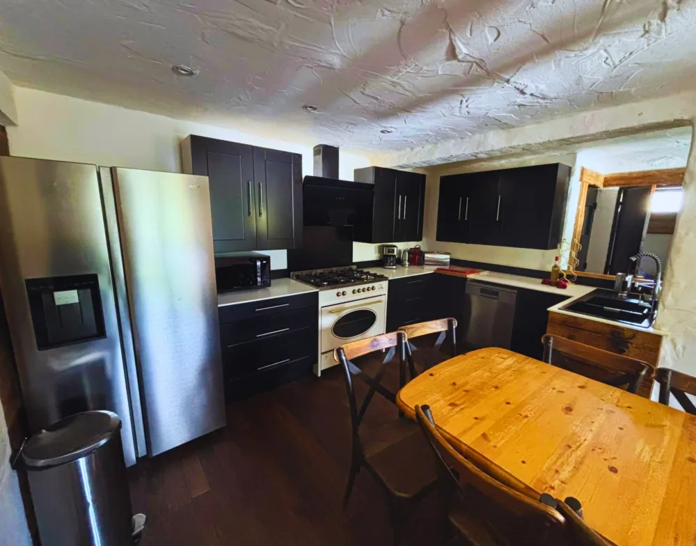 Une cuisine de chef pour toute la tribu : entièrement équipée avec piano de cuisson et réfrigérateur américain, elle s'ouvre directement sur la salle à manger.