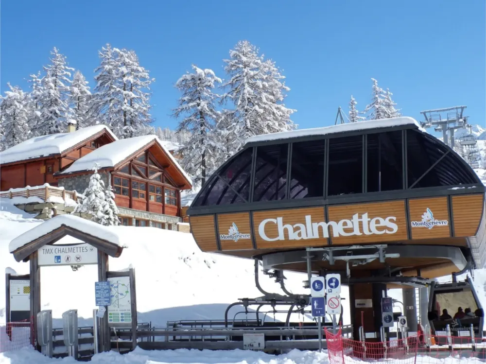 Chalet le Soleil sous la neige vue de la piste de ski et du télémix des Chalmettes