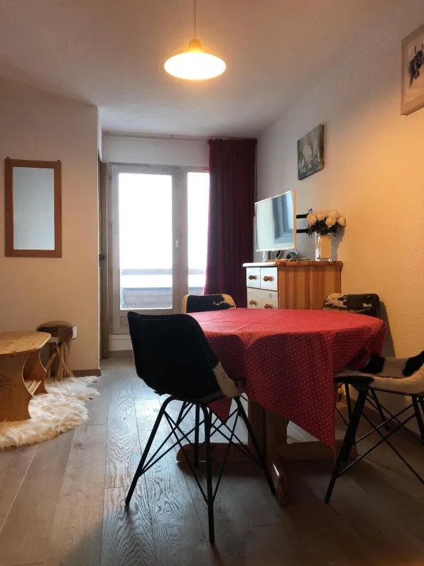 living room with round table and chairs , view through the french window on to the ski slopes .