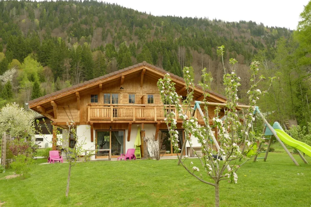 Le chalet vue de devant, en arrière plan la forêt où se c accent de nombreux animaux sauvages (chevreuils, cerfs, renards)