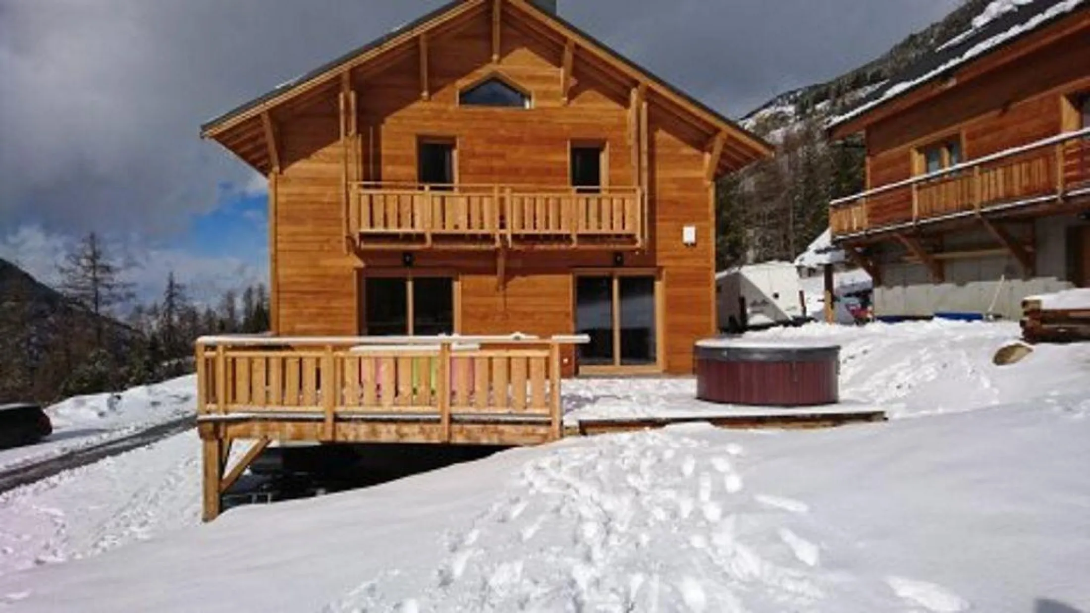 façade sud du chalet avec jacuzzi et terrasse hiver