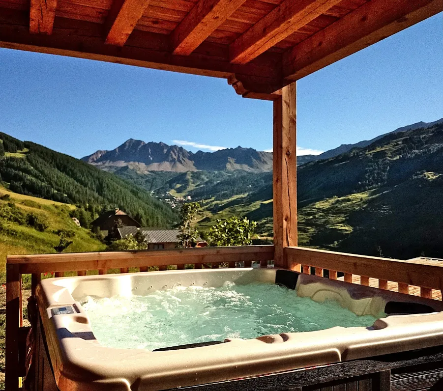Jacuzzi extérieur 5 places chauffé toute l'année à 37°, idéal pour se prélasser au soleil face à la montagne après une belle journée de randonnées.