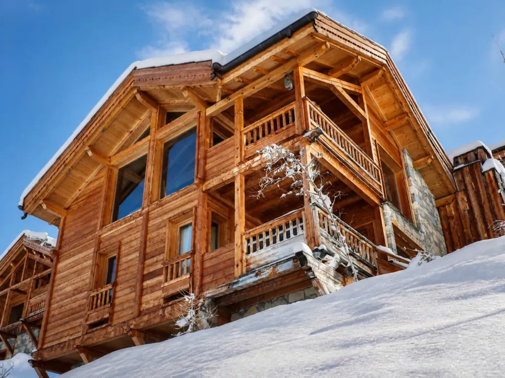 The main facade of Chalet Hosszu in Vars in winter, covered in snow, with a mountain atmosphere and the feel of a high-end chalet.