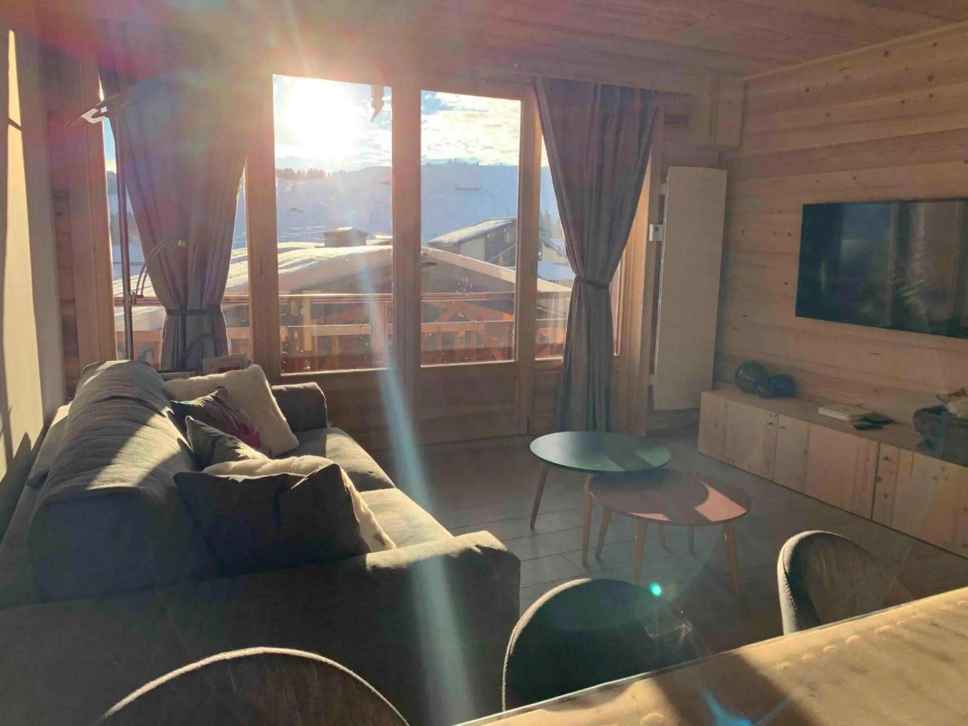 Salon cosy, en hiver avec Soleil avec la vue sur le mont Bisanne et les pistes. TV 4K, Apple TV, Amazon Prime Video, Netflix, Wifi debit Fibre, et canapé premium.