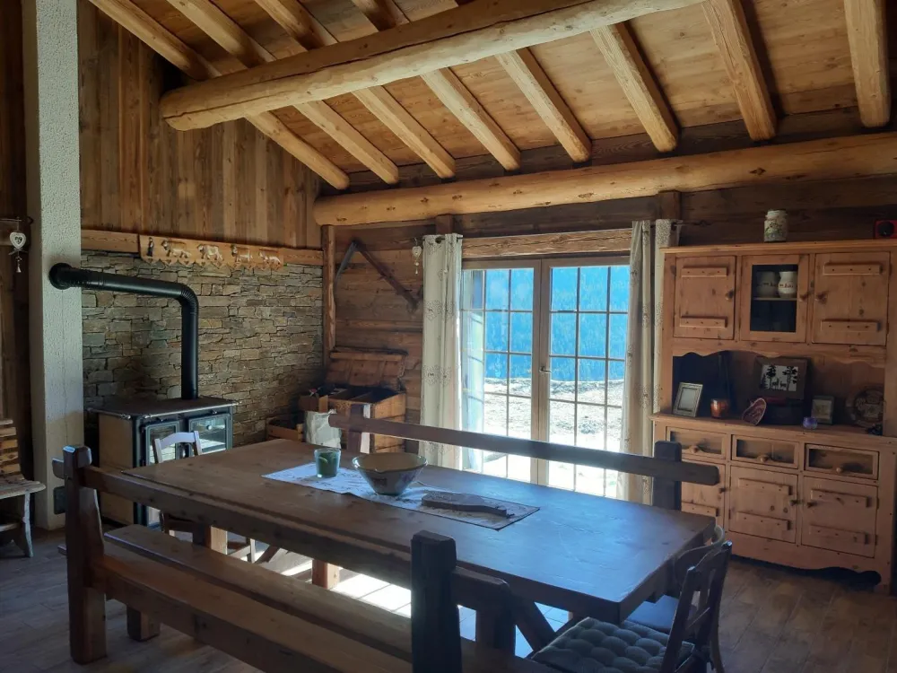 Coin séjour avec cuisinière à bois donnant sur une terrasse 